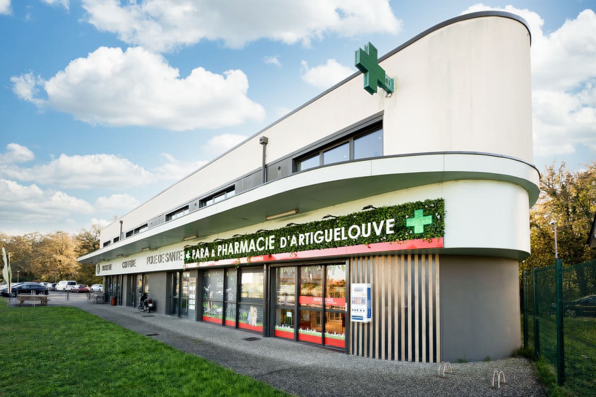 Façade de la Para & Pharmacie d'Artiguelouve : bandeau végétalisé, ligne rouge et croix verte