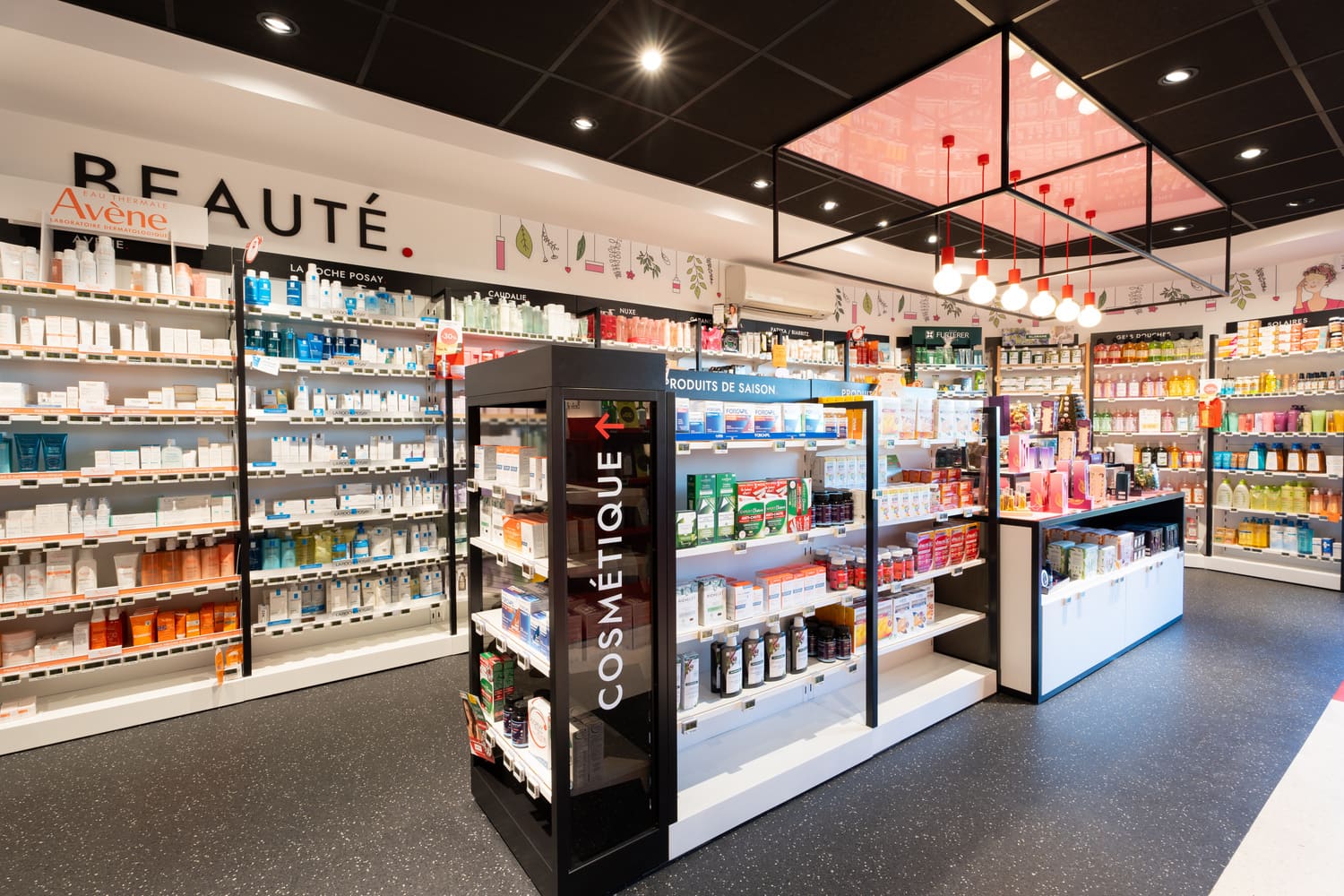 Univers Beauté de l'officine d'Artiguelouve : mur de marques et cadre lumineux suspendu