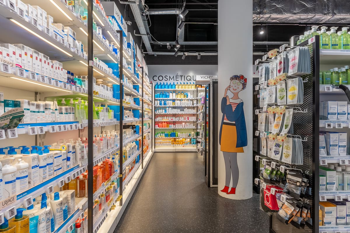 Allée cosmétique d'une officine Médiprix à Montpellier, avec une illustration murale sur colonne